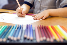 little girl playing with colors. The focus is on the hand laying on the paper